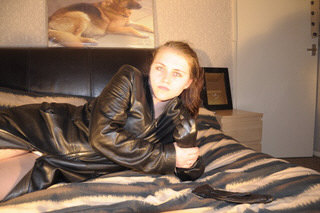 girl-in-leather-gloves-putting-on-leather-boots-in-leather-jacket-in-room